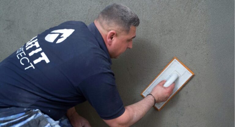Technicien HUMY appliquant un enduit sur mur de cave