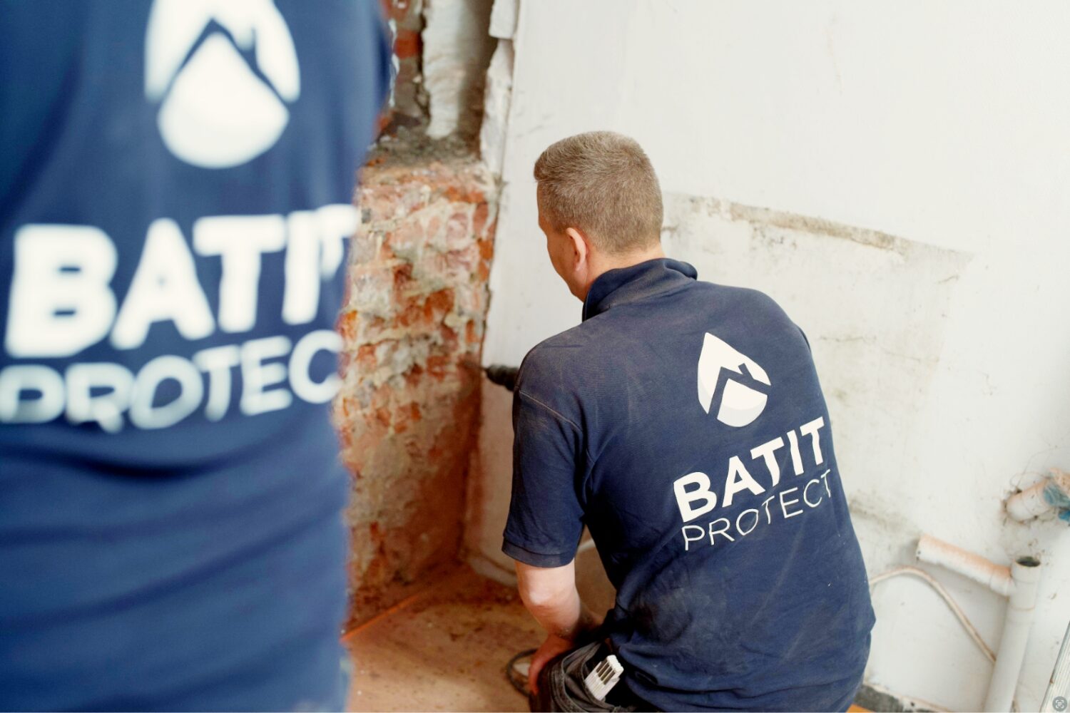 Techniciens HUMY réalisant un traitement humidité dans les murs