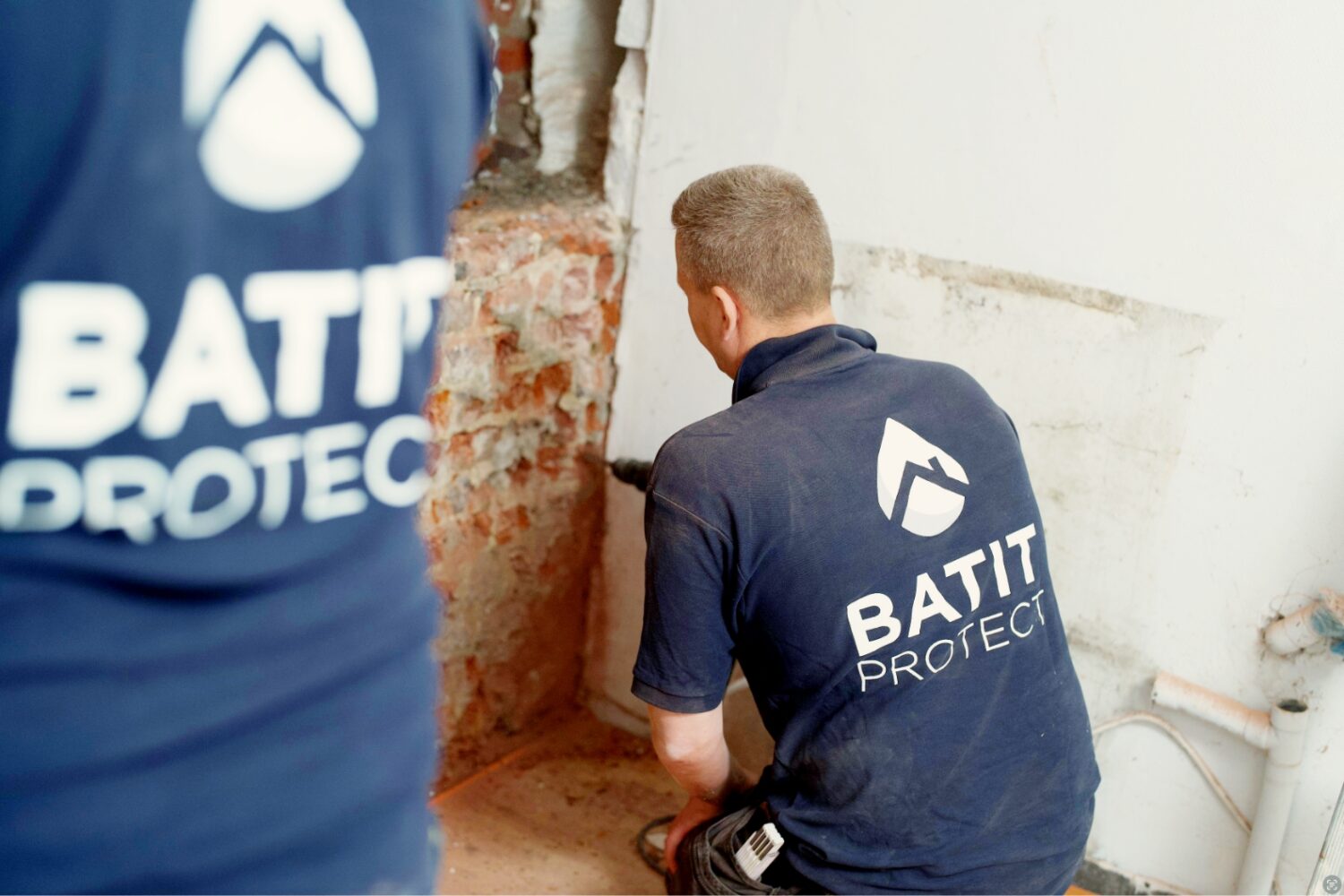 Techniciens HUMY réalisant un traitement humidité dans les murs