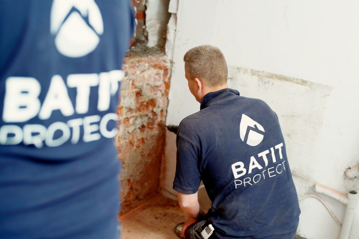 Techniciens HUMY réalisant un traitement humidité dans les murs